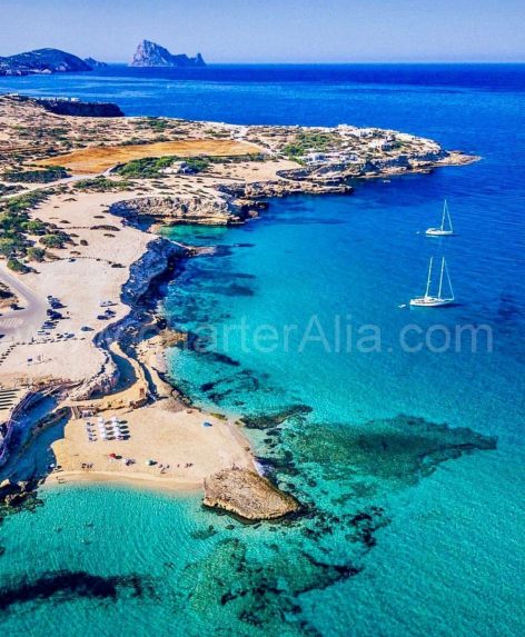 Aerial view of Cala Comte with sailboat for hire in Ibiza anchored at shore