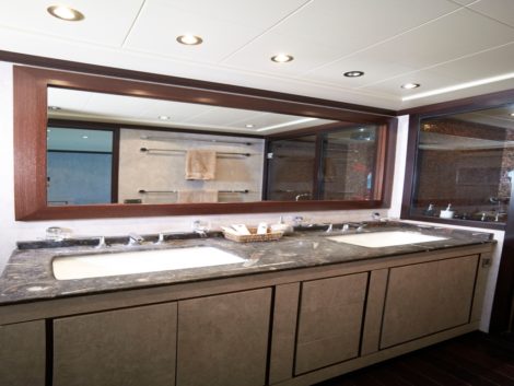 Luxuriöses Badezimmer in der Hauptkabine mit Doppelwaschbecken und großem Spiegel der Superyacht Mangusta 92