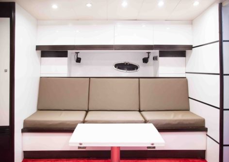 Comfortable lounge with retractable table inside the Stealth 50 yacht for rent in Ibiza and Formentera