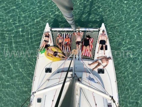 Aerial view of Lagoon 380 catamaran from top of stick with customers enjoying the bow nets