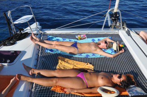 Laying on the nets of the catamaran for hire in Mallorca