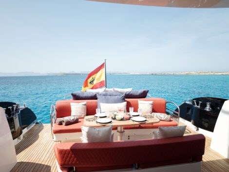 Canapé arrière avec grande table sur le yacht Sunseeker Predator 92 à louer où vous pourrez déguster un délicieux menu préparé par notre chef privé