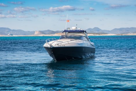 Vue de face avec toile de fond spectaculaire de notre yacht de luxe Sunseeker 48 à louer à Ibiza et Formentera