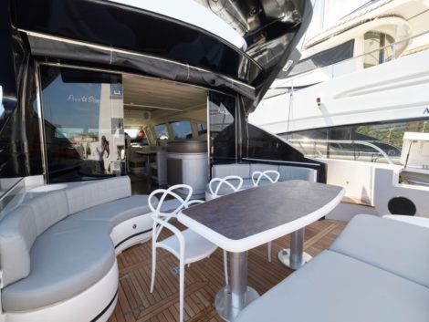 Zona divani e tavoli accanto al solarium posteriore dello yacht Mangusta 92
