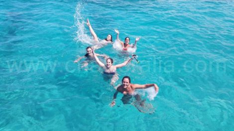 meninas em Ibiza nadando em direcao ao barco de aluguer