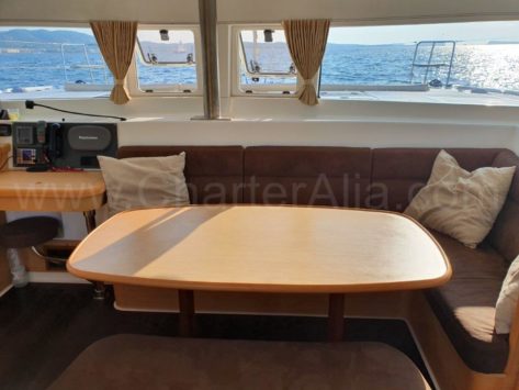 Vista frontal de la mesa de comedor en el salon del catamaran de alquiler Lagoon 420